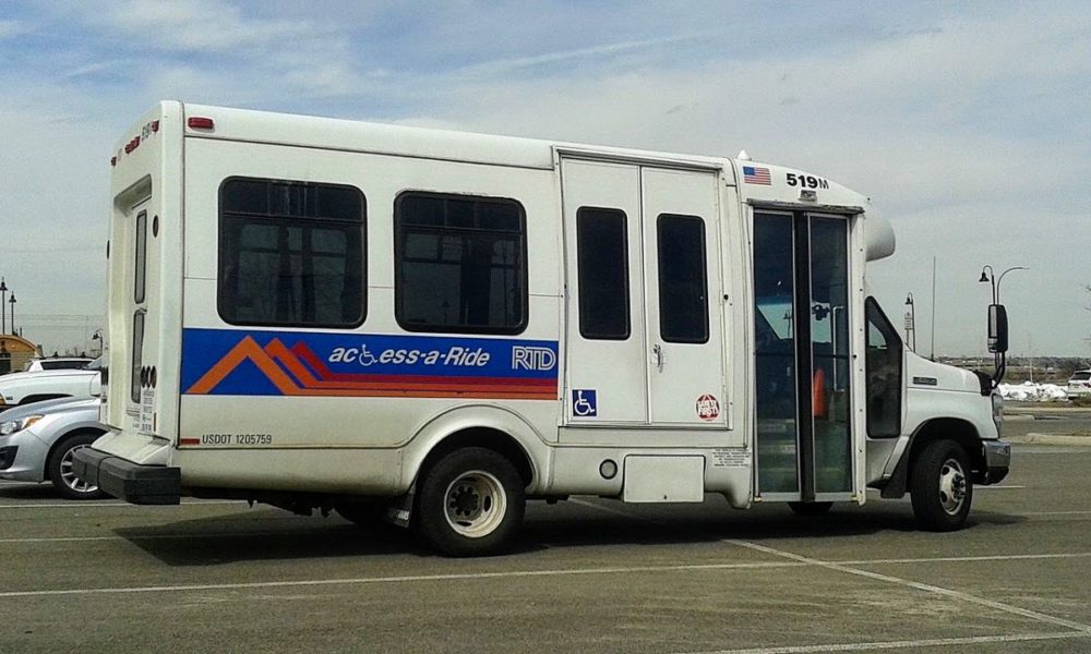 Close up of an Access-a-Ride vehicle in a parking lot.