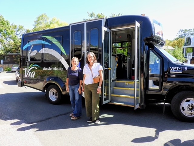 Two women standing beside a Via Mobility Services paratransit vehicle during a Week Without Driving 2026 ride-along in Boulder